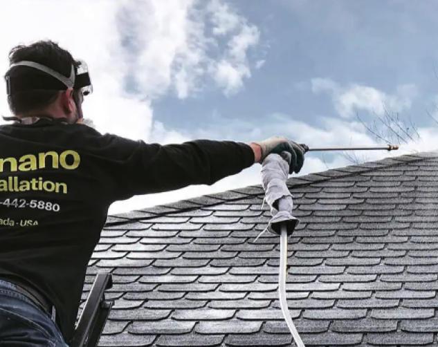 detroit gonano team member spraying roof with shingle saver